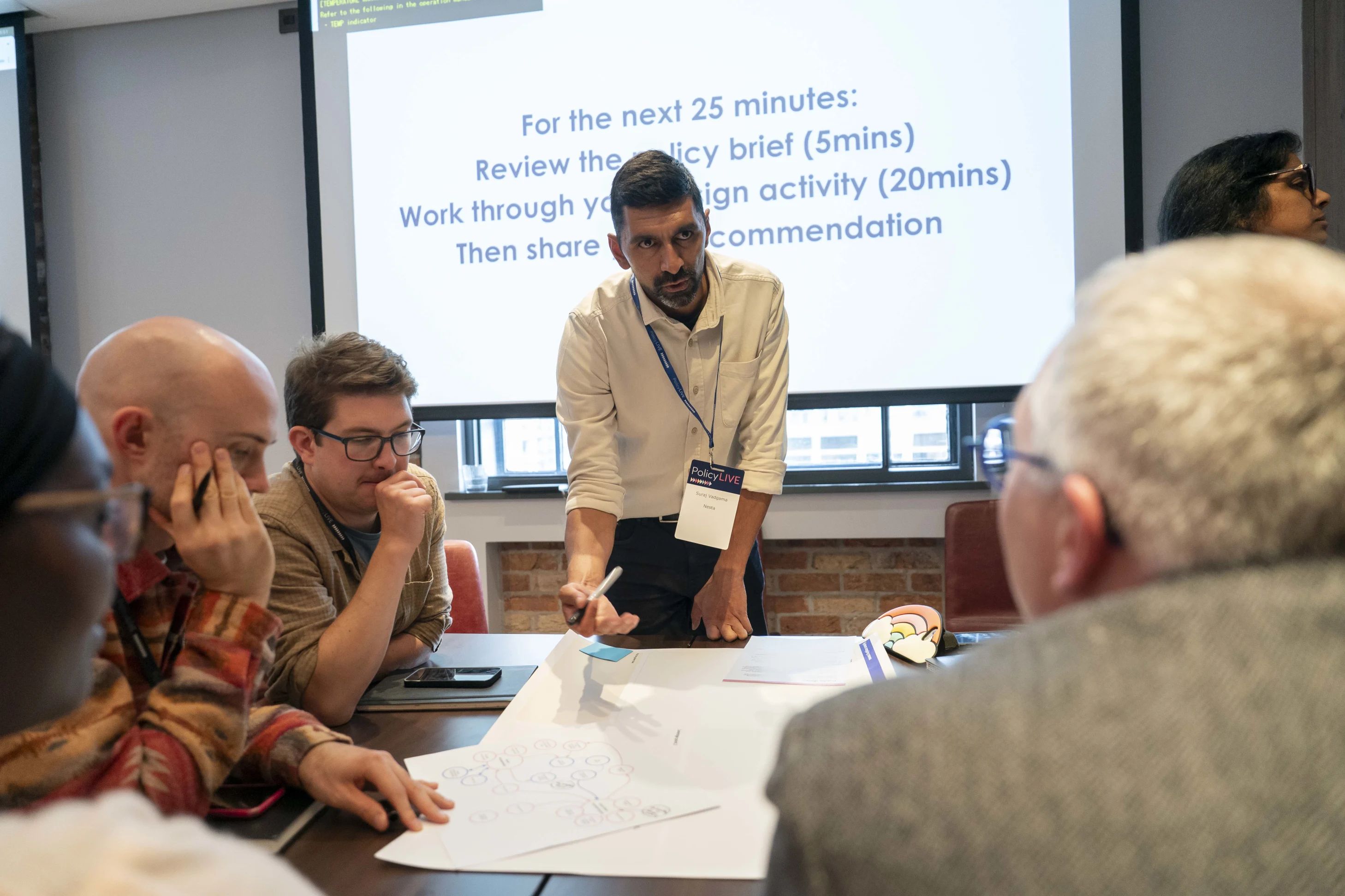 People looking at a worksheet during a workshop.